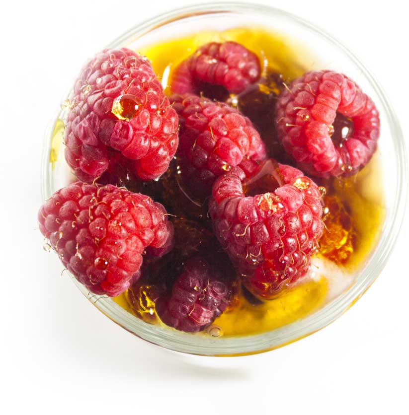 Raspberries and honey in a glass of yogurt